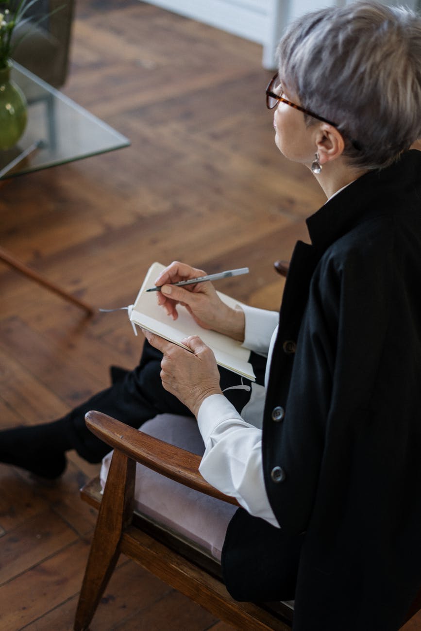 woman in black blazer holding white tablet computer